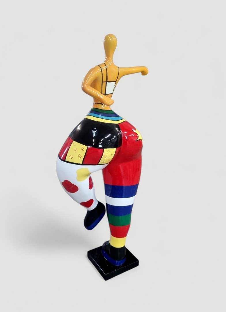Bunte Skulptur einer tanzenden Figur Bunte Skulptur einer tanzenden Figur mit einem farbenfrohen Muster auf dem Körper und einer gelben Kopfpartie.
