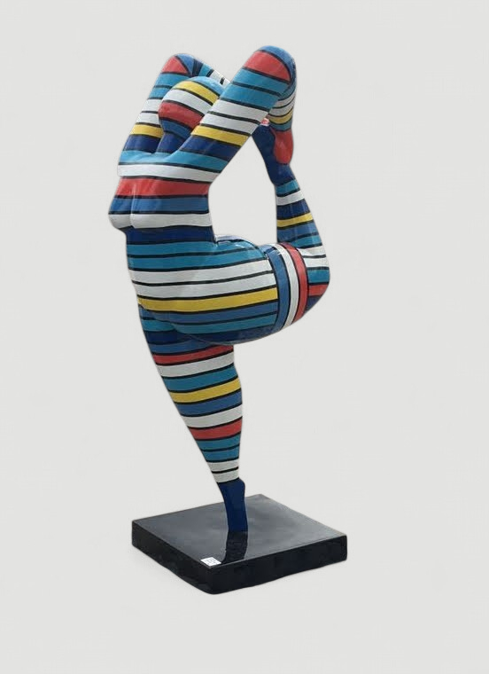 Nana Skulptur: farbenfrohe Figur in Yoga-Pose, Bein nach hinten gestreckt.
