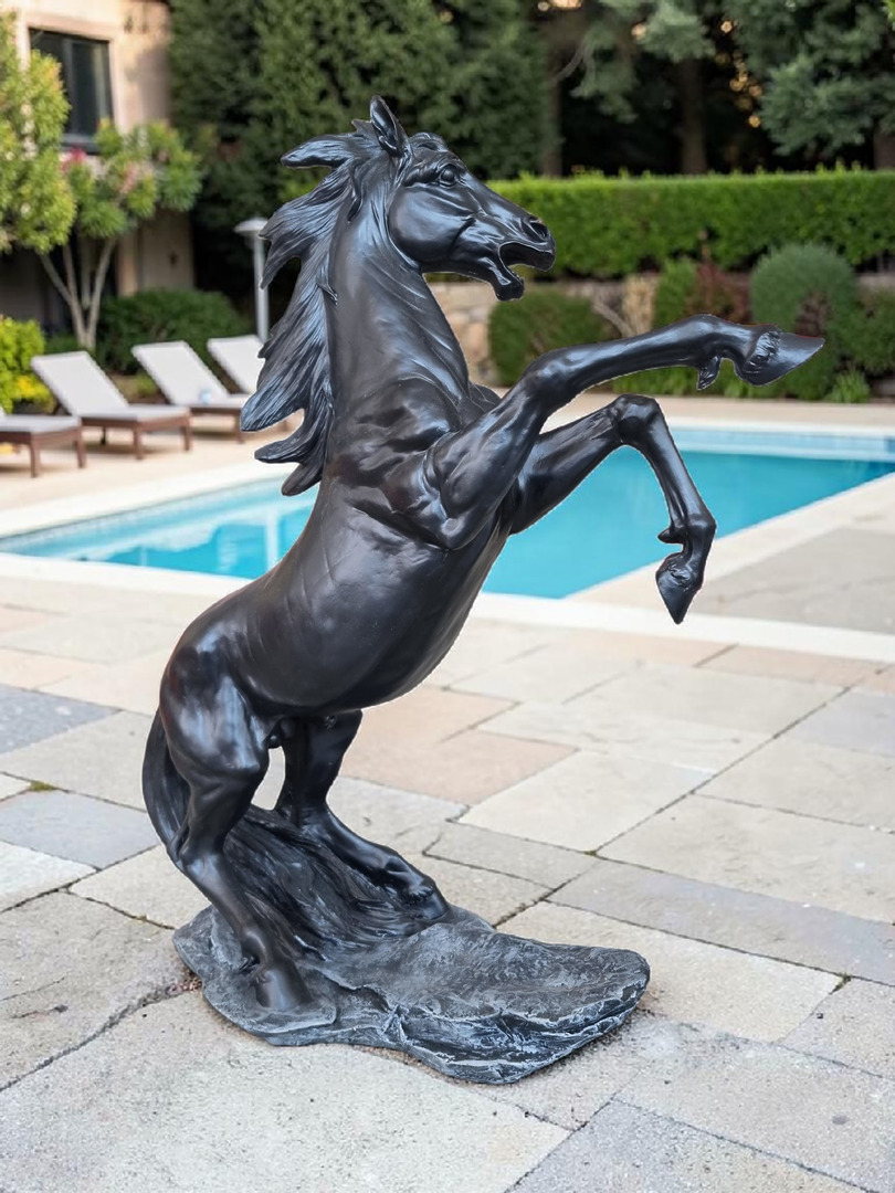 Schwarz lackierte Gartenfigur eines steigenden Pferdes mit erhobenen Vorderbeinen.