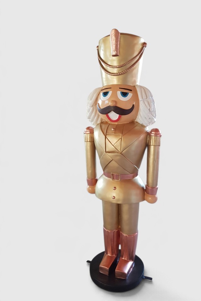 Lebensgroßer XXL Nussknacker in goldener Uniform mit weißem Haar und Schnurrbart.