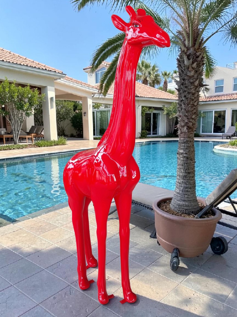 Rote Giraffenstatue im Garten neben einem Pool
