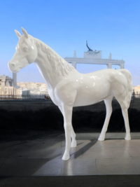Weiße Pferdeskulptur vor dem Brandenburger Tor in Berlin.